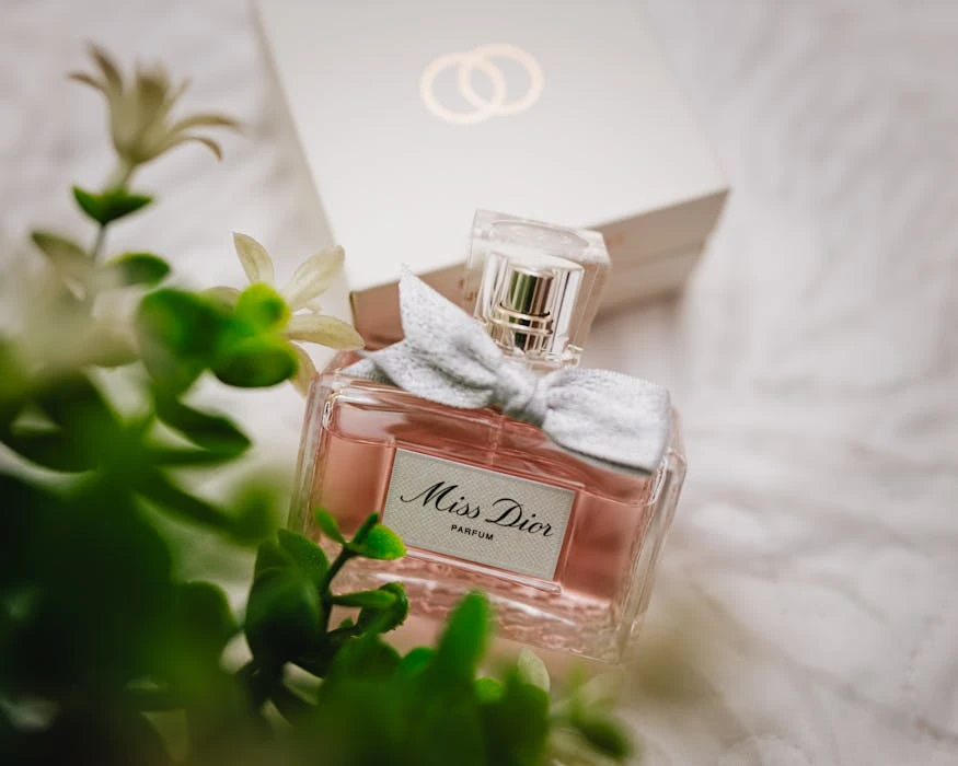 Close-up of a Miss Dior perfume bottle with soft floral background.